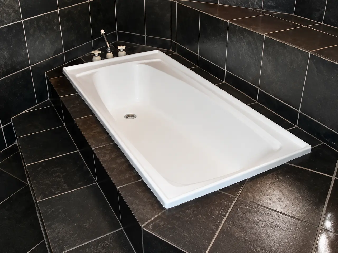 Finished white bath in a tiled bathroom