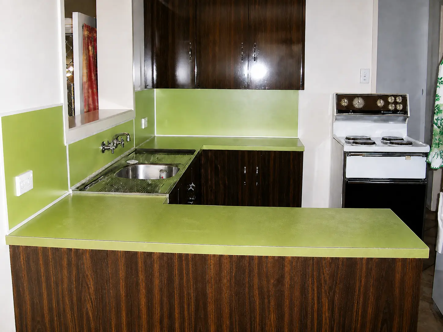Used kitchen before resurfacing with a worn lime-green benchtop and splashback