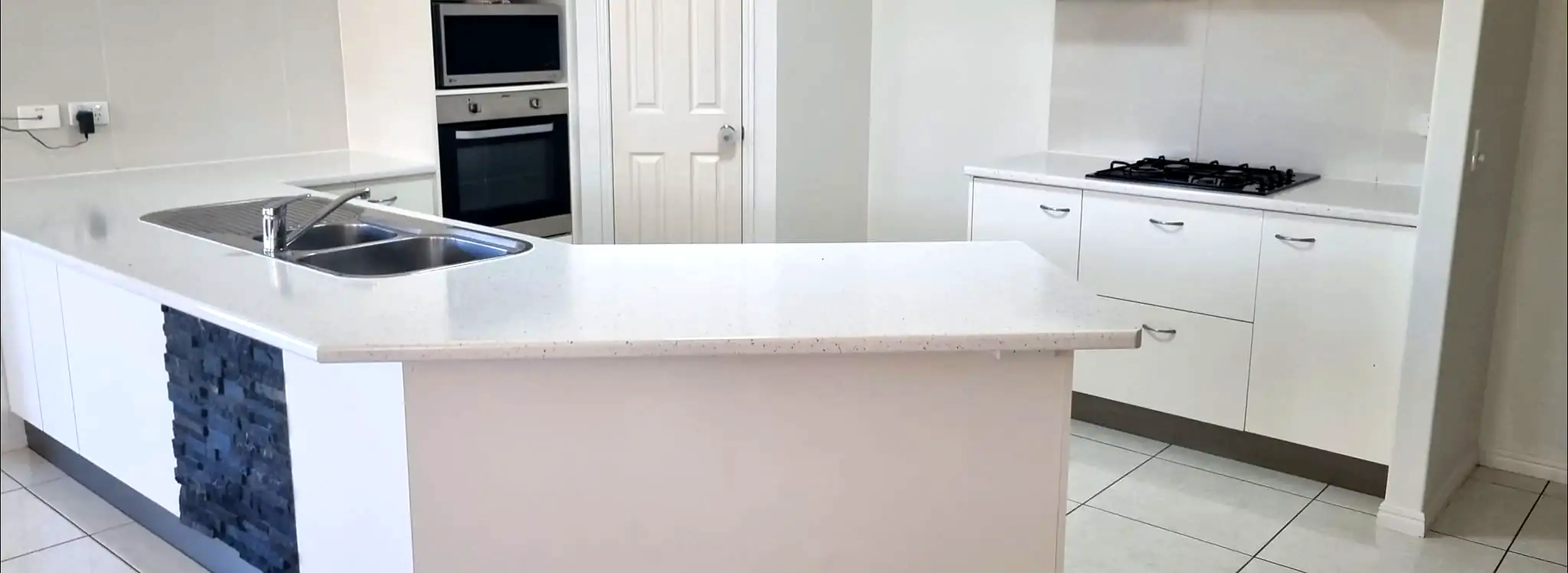 Finished bright white kitchen benchtop and cabinetry